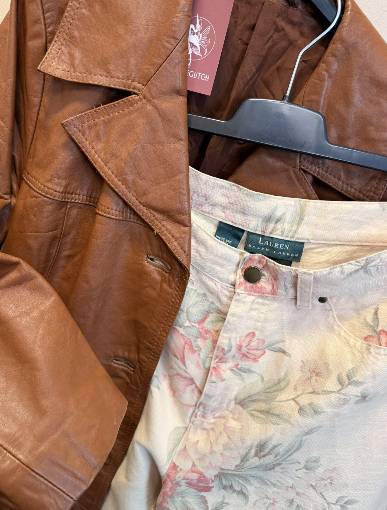 Cognac leren vintage jas naast een Ralph Lauren broek met pastelbloemenprint
