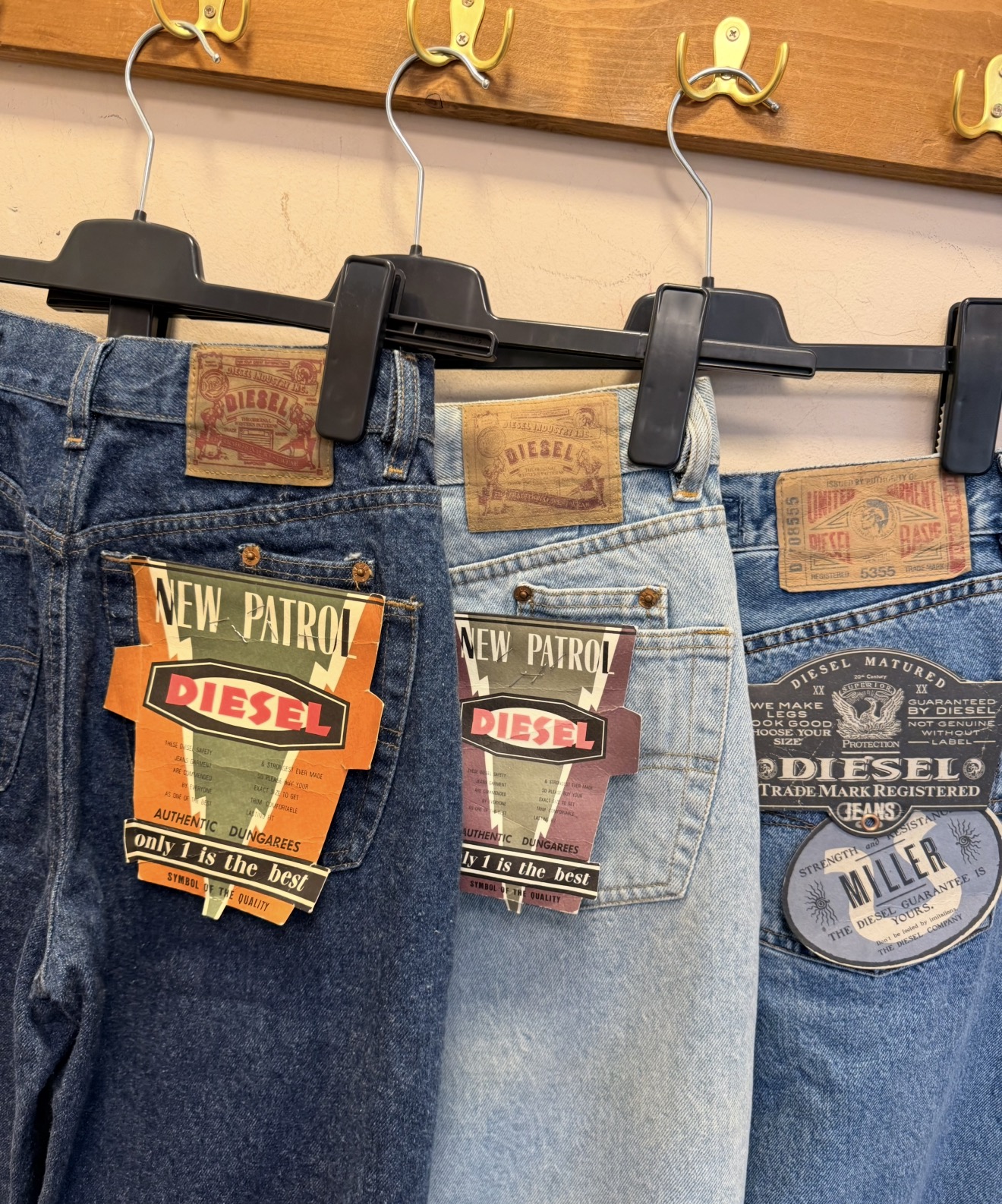 Drie vintage Diesel jeans met originele labels aan zwarte broekhangers
